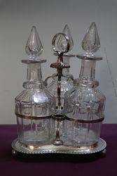 Antique Cut Glass 3 Bottle Tantalus in a Silver Plated Stand #